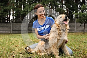 Female volunteer with homeless dog at animal shelter