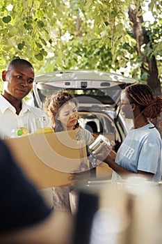 Female volunteer provides canned goods photo