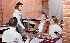 Female waiter bringing order to visitors