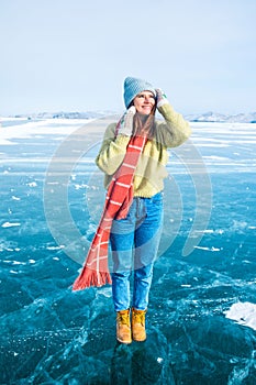 Female wanderer dressed in fashionable hat and mittens and scarf standing outdoors