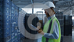 Female warehouse worker checking shipment boxes inspecting delivery package