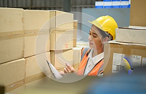 Female warehouse worker Counting items in an industrial warehouse on the factory\'s mezzanine floor.