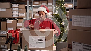 Female warehouse worker sealing cardboard boxes with glue tape. Hard Job at Christmas