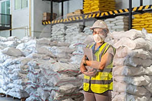 A Female warehouse worker wear a mask in alum or chemical warehouse storage. International export business concept