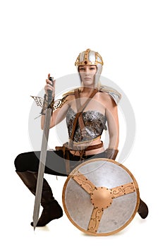 Female warrior kneeling with sword and shield