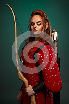 Female warrior posing with bow and arrows.