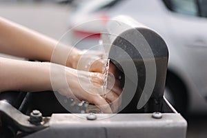 Female wash rug in water. Close-up woman& x27;s hand in front of car on sel servise car wash