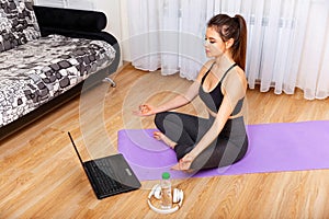 Female watching online classes. Home workout. Woman doing yoga.