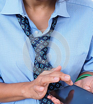 Female wearing business attire texts on mobile phone