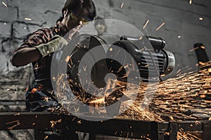 female welder in protective googles using welding torch