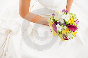 Female in white wedding dress holding flowers