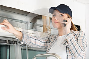 female window installer talking on cellphone