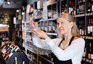 Female winemaker checking wine in store