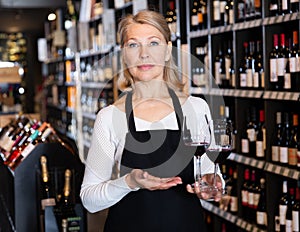 Female winemaker offering glass of wine for tasting