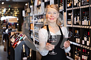 Female winemaker offering glass of wine for tasting