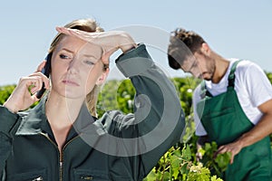 Female wineyard worker talking about issue on phone
