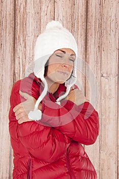 Female in winter wear appears cold hugging herself eyes closed