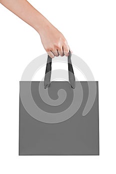 A female(woman) hand hold a gray shopping bag(paper bag) at the