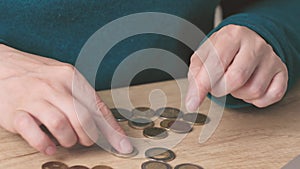 female woman hands calculating counting money coins euro cents on wooden table