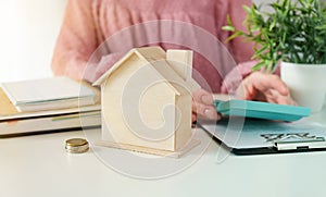 Female woman hands holding home model, small miniature white toy house. Mortgage property insurance dream moving home and real
