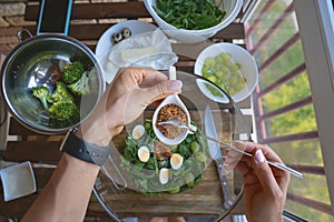 Female woman hands on wooden kitchen table with vegetables cooking ingredients, spoon and tools, top view, phone. Free