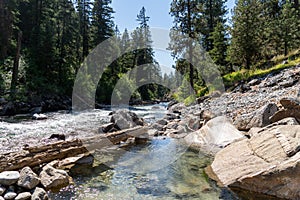 Female woman sitting in a natural hot springs uses her arms to mix hot and cold water to regulate the tempature of the Sacajawea photo