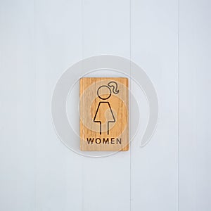 Female or woman toilet wood sign on the wall. copy space background