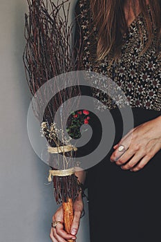 Female woman wiccan witch holding flower decorated witch broom in hand