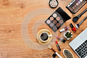 female wooden desktop with Laptop, notepad, Lipstick, powder, comb, women`s jewelry. Top view.