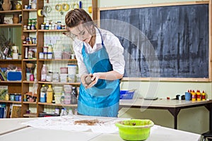Female Worker in Apron Moulding a Piece of Clay