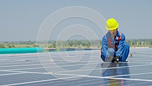 Female worker attaching solar panels to the roof of the factory