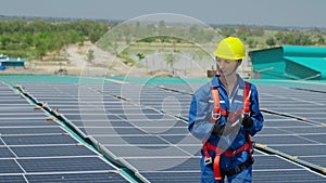 Female worker attaching solar panels to the roof of the factory