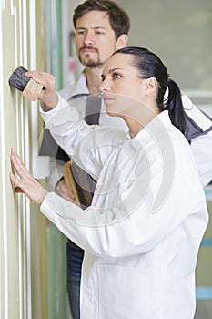 Female worker brushing wall