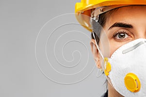 Female worker or builder in helmet and respirator