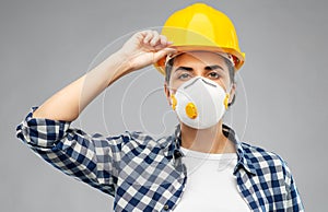 Female worker or builder in helmet and respirator