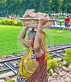 Female worker carries rock waste on her hat