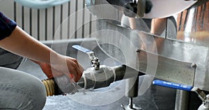 Female worker checking a pipe in distillery factory 4k