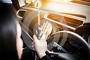 Female worker cleaning car inside dashboard