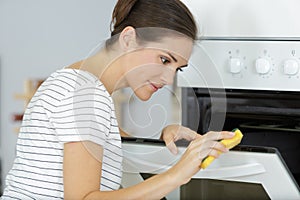 female worker cleaning oven