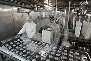 Female Worker by Conveyor at Food Factory