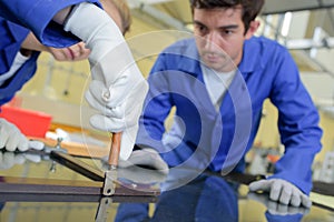 Female worker cutting glass