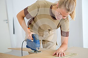 Female worker cutting plywood