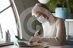Female worker disinfect office workplace with sanitizer photo