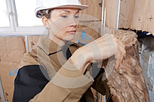 Female worker fitting insulation
