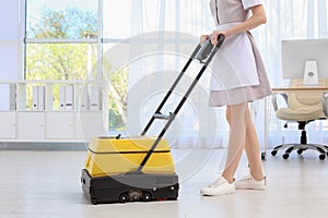 Female worker with floor cleaning machine
