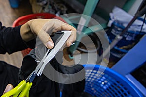 Female worker hand cutting lining paper on staff uniform on Garment Manufacturers at Kota Kinabalu, Sabah, Malaysia