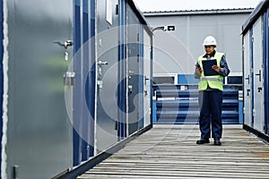 Female worker holding clipboard at shipping docks