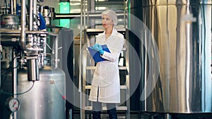 Female worker is inspecting an equipped factory unit