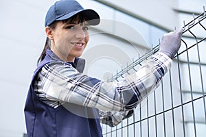 female worker installing welded metal mesh fence