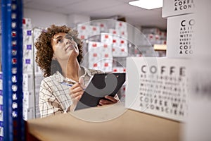 Female Worker In Logistics Distribution Warehouse Using Clipboard